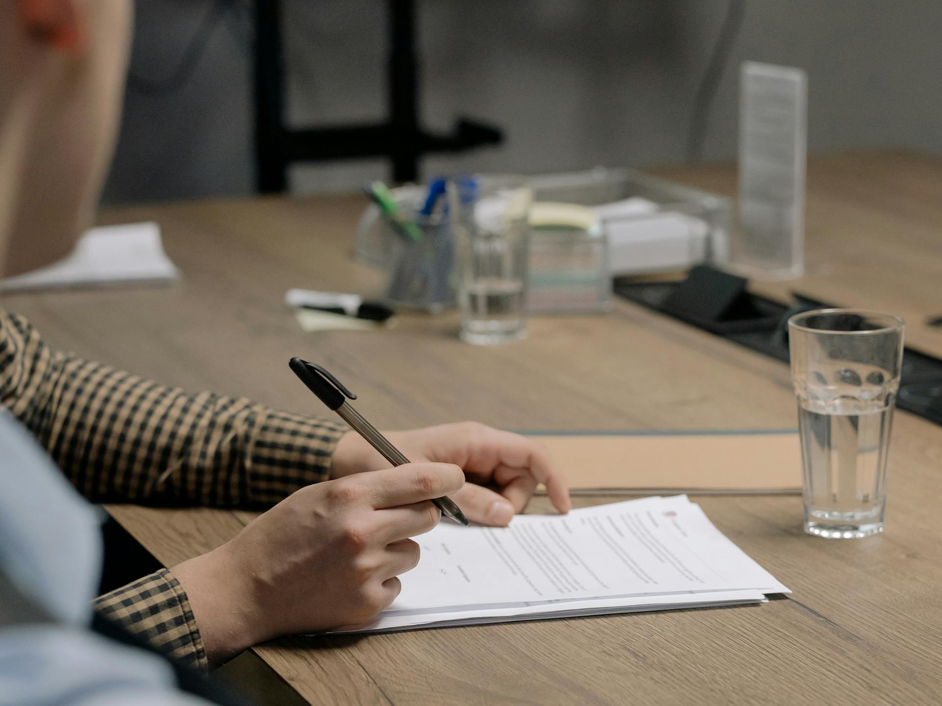 LLC formation papers, business license certificate, and resale certificate stacked on a wooden desk